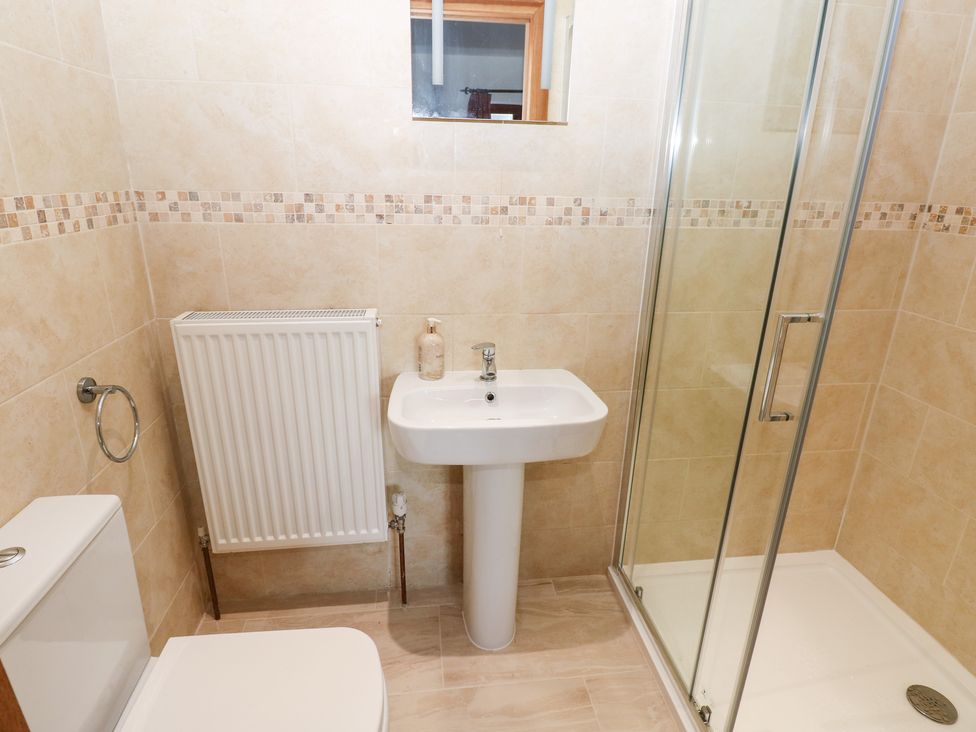 A bathroom with a shower, sink, and toilet at Ty-Gan Dderwen, Llanelli