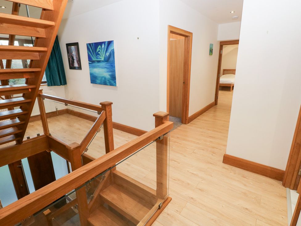 A hallway with stairs and doors leading to rooms at Ty-Gan Dderwen in Llanelli