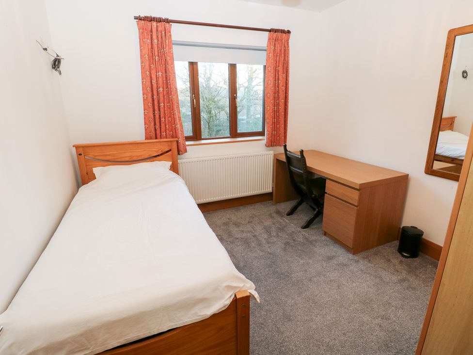 A bedroom with a bed and desk at Ty-Gan Dderwen Llanelli