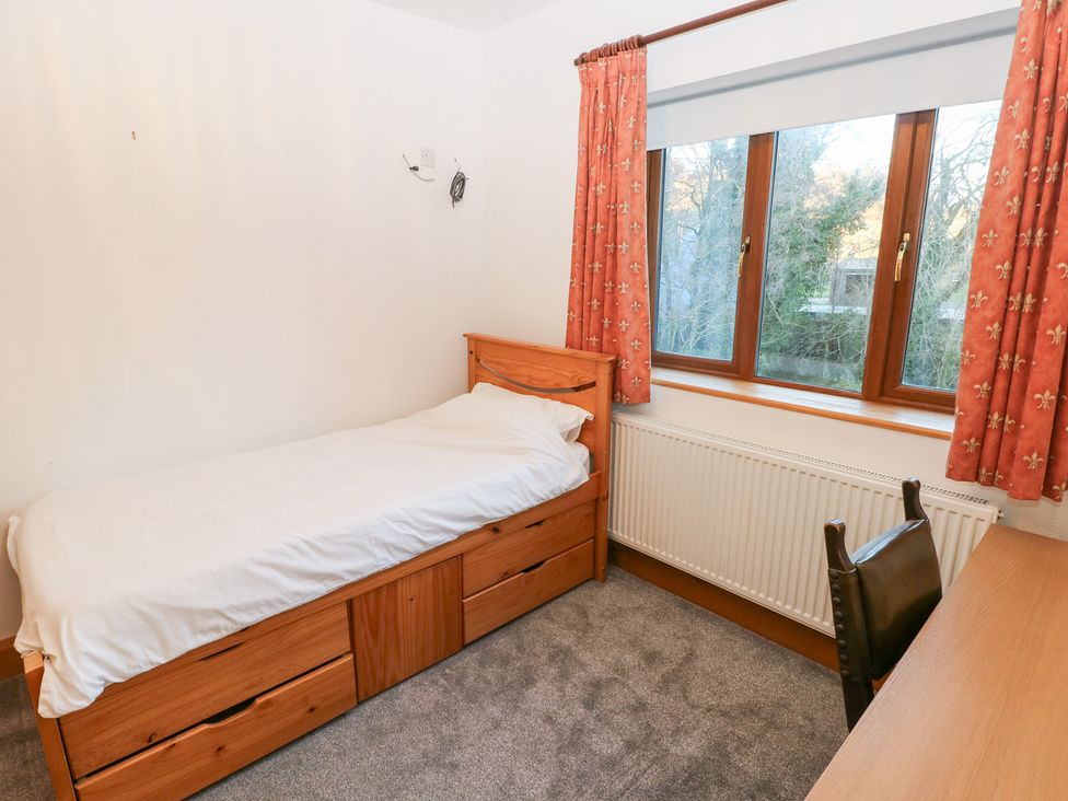 A bedroom with a bed and a desk at Ty-Gan Dderwen in Llanelli
