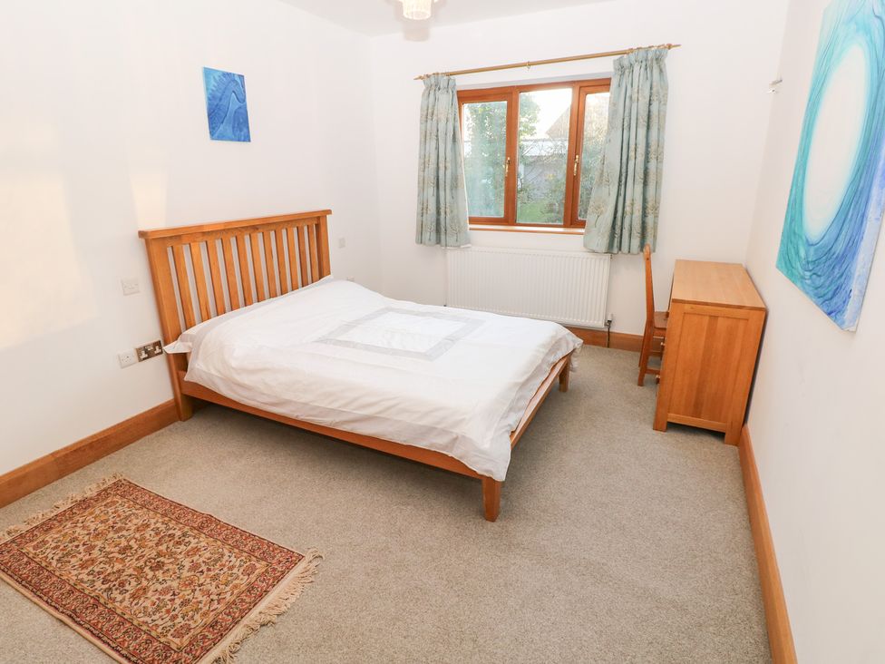 A bedroom with a bed and a window at Ty-Gan Dderwen in Llanelli