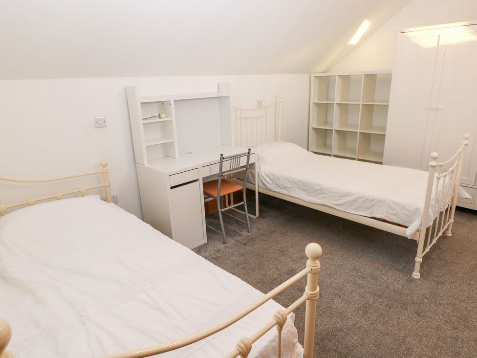 A bedroom with two beds and a desk at Ty-Gan Dderwen in Llanelli