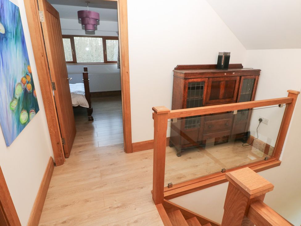 A hallway with a console table and a door leading to a bedroom at Ty-Gan Dderwen Llanelli