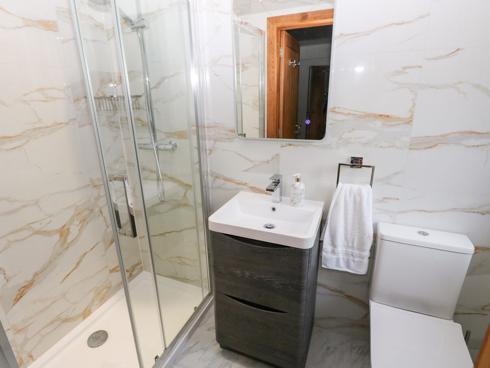 A bathroom with a shower, sink and toilet at Ty-Gan Dderwen in Llanelli