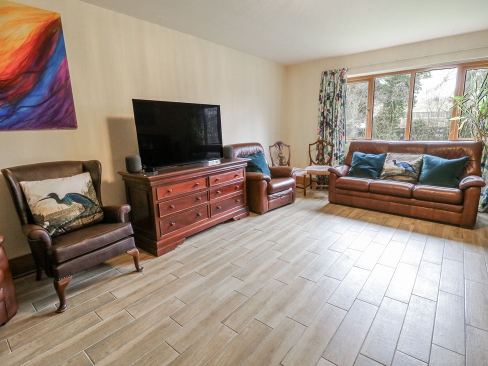 A living room with a sofa and television at Ty-Gan Dderwen in Llangennech