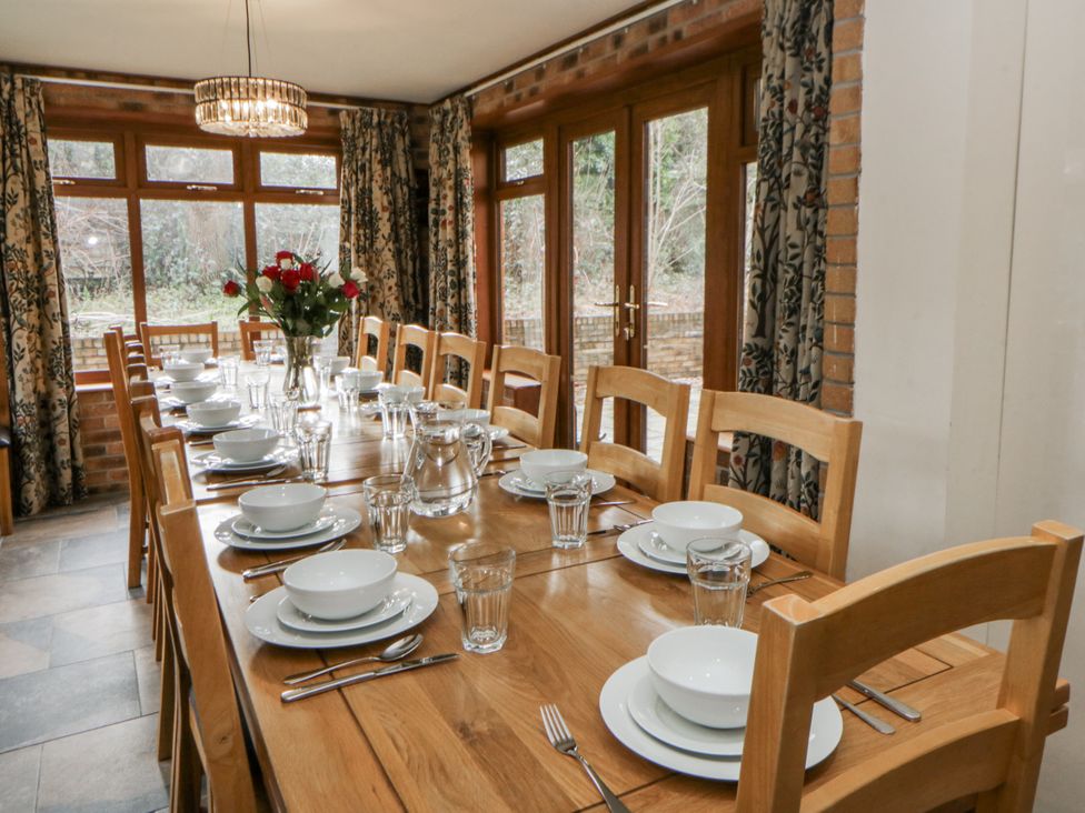 A dining room with a large table set for a meal at Ty-Gan Dderwen in Llangennech