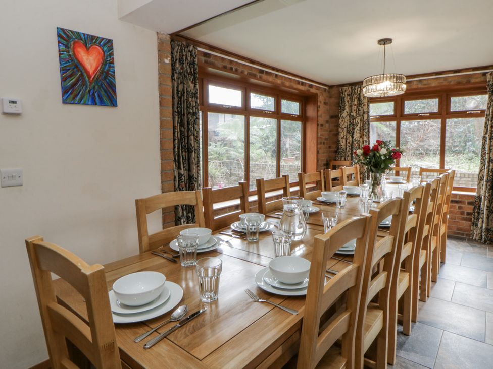 A dining room with a large table set for a meal at Ty-Gan Dderwen in Llangennech
