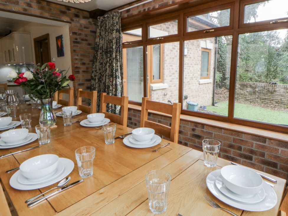 A dining room with a table set for meals at Ty-Gan Dderwen in Llangennech