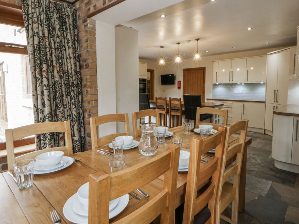 A dining room with a table set for dinner at Ty-Gan Dderwen in Llangennech