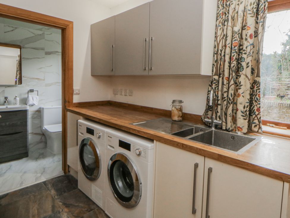 A laundry room with washing machine and dryer at Ty-Gan Dderwen Llangennech