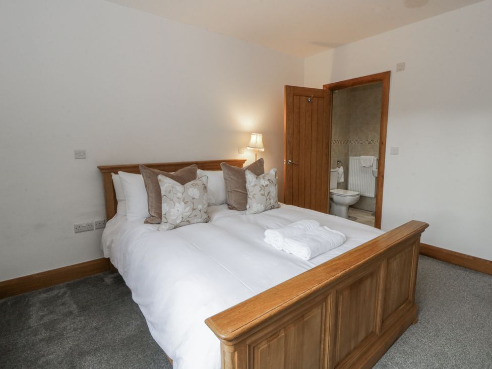 A bedroom with a bed and pillows at Ty-Gan Dderwen in Llangennech