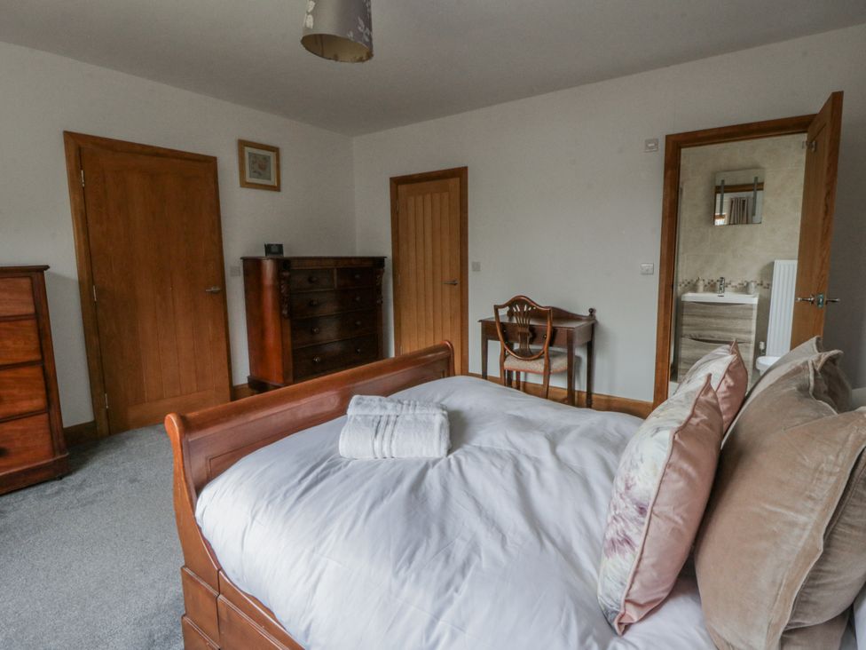 A bedroom with a bed and dresser at Ty-Gan Dderwen in Llangennech