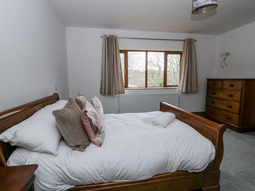 A bedroom with a bed and chest of drawers at Ty-Gan Dderwen in Llangennech