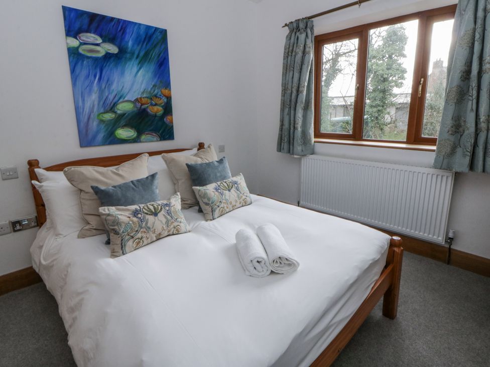 A bedroom with a bed and artwork at Ty-Gan Dderwen in Llangennech