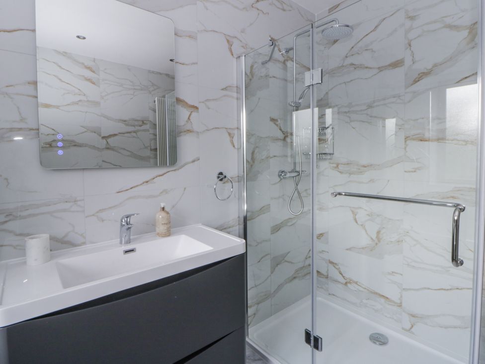 A bathroom with a shower and sink at Ty-Gan Dderwen in Llangennech