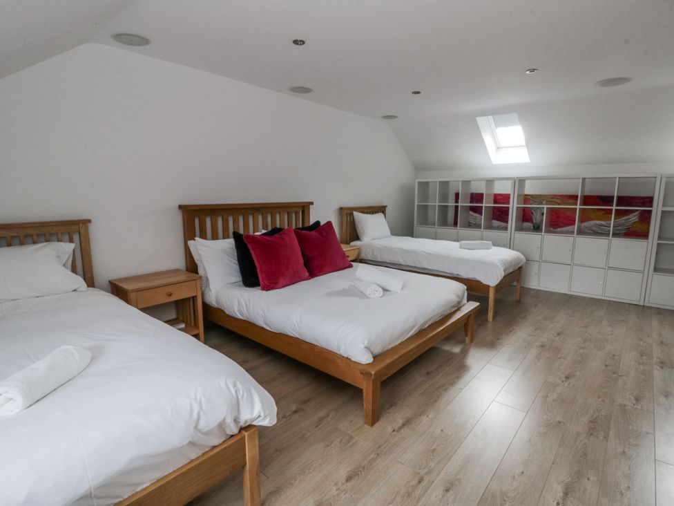 A bedroom with three beds and shelving at Ty-Gan Dderwen in Llangennech