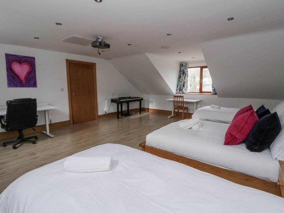 A bedroom with beds, desk, and projector at Ty-Gan Dderwen in Llangennech