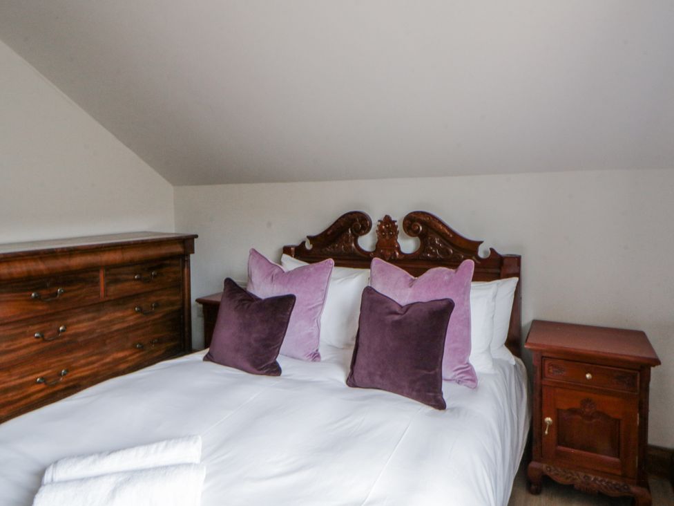 A bedroom with a bed and nightstand at Ty-Gan Dderwen in Llangennech