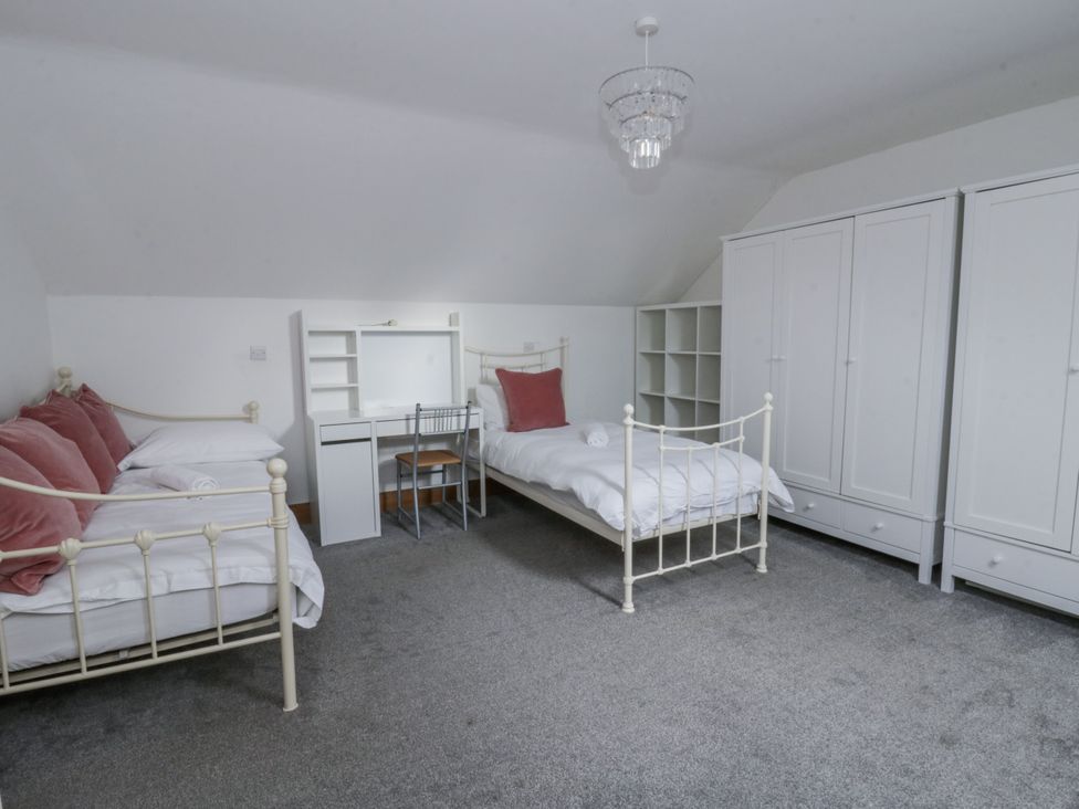 A bedroom with two beds and a desk at Ty-Gan Dderwen in Llangennech
