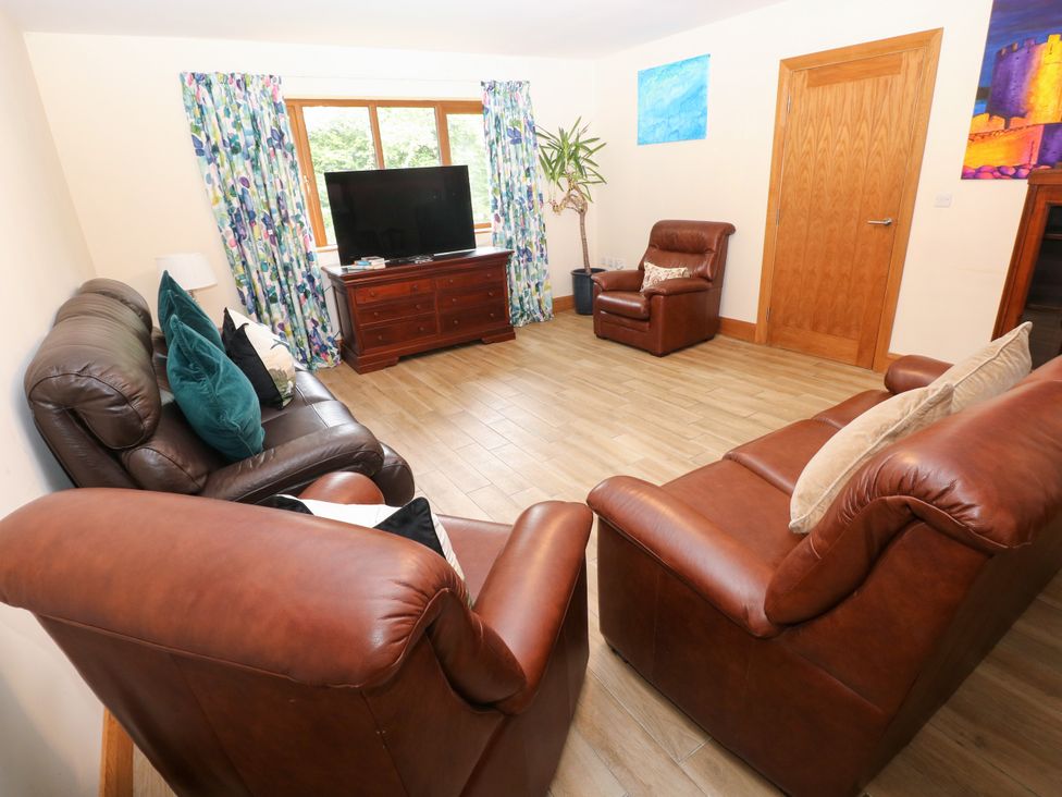 A living room with sofas and a television at Ty-Gan Dderwen, Llangennech, Llanelli