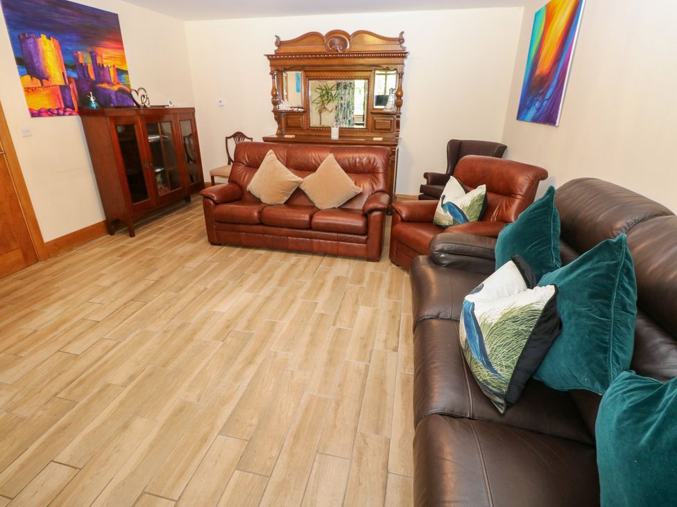 A living room with a sofa and an armchair at Ty-Gan Dderwen Llangennech, Llanelli
