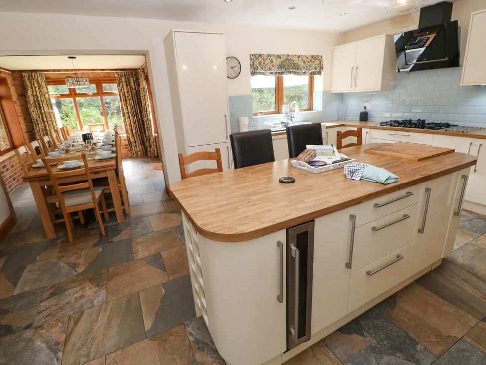 A kitchen with an island and dining area at Ty-Gan Dderwen in Llangennech, Llanelli