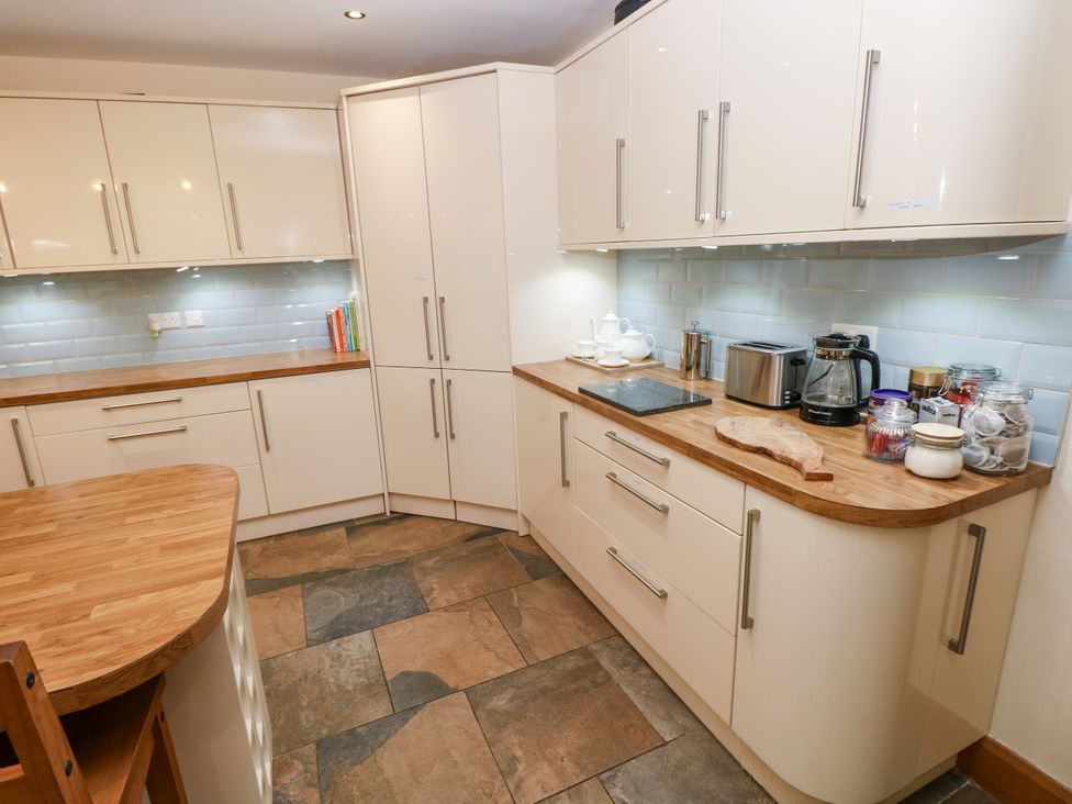 A kitchen with cabinets and appliances at Ty-Gan Dderwen in Llangennech, Llanelli