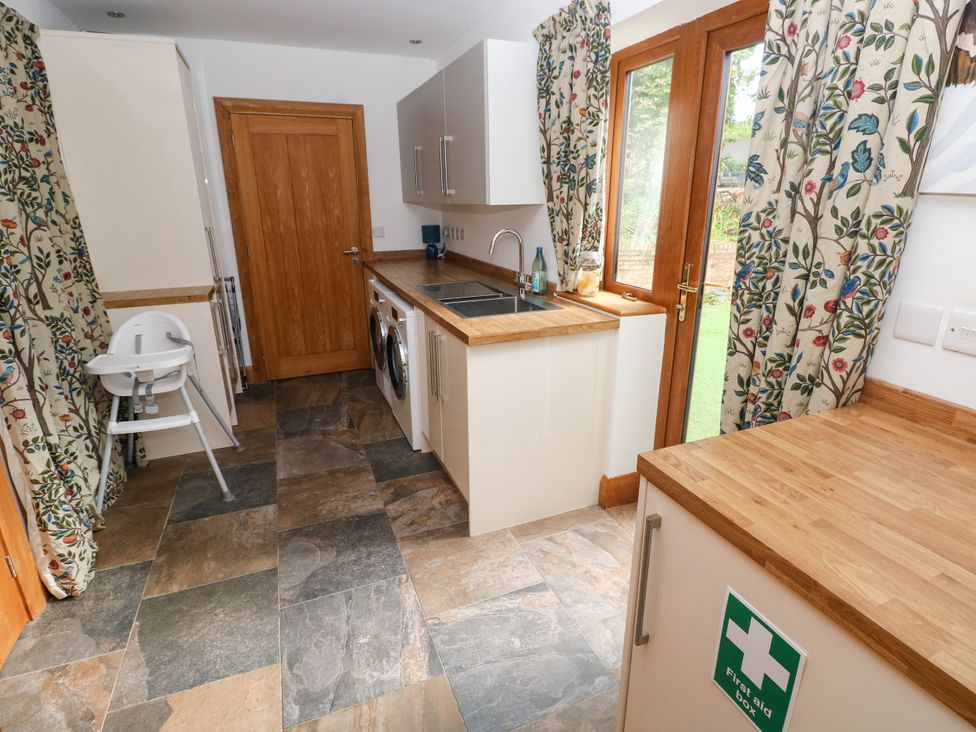 A kitchen with a sink and washing machine at Ty-Gan Dderwen Llangennech, Llanelli