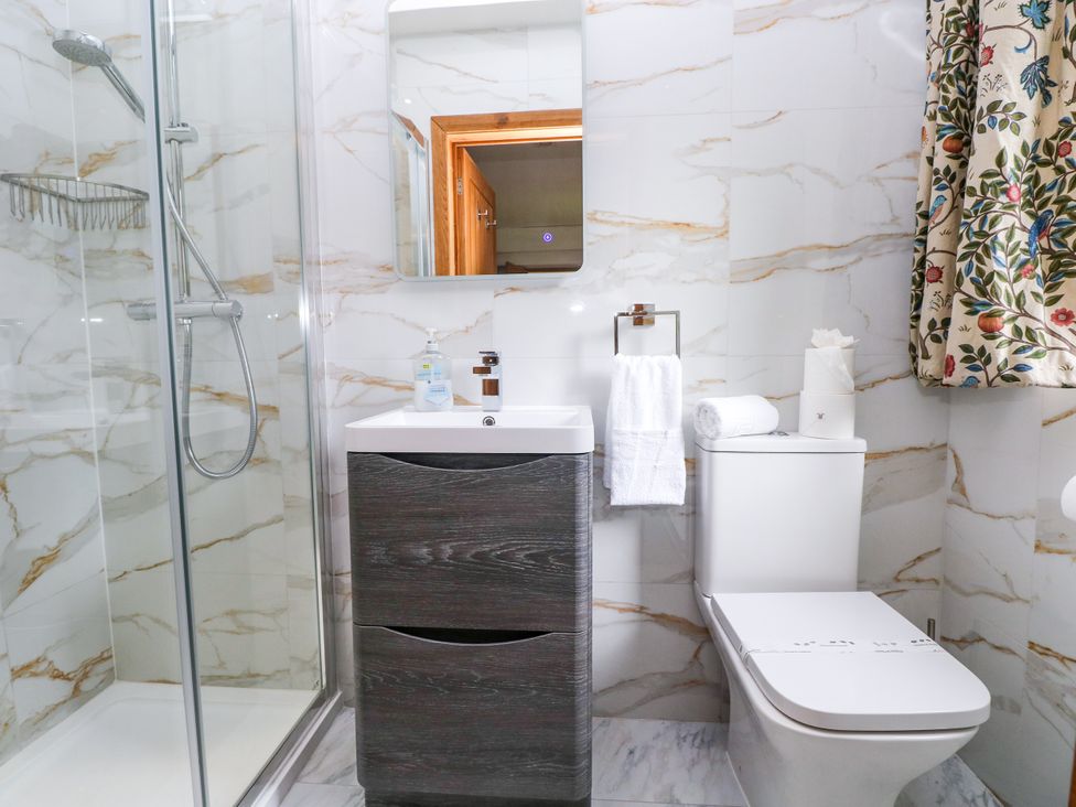 A bathroom with a shower, sink, and toilet at Ty-Gan Dderwen in Llangennech, Llanelli
