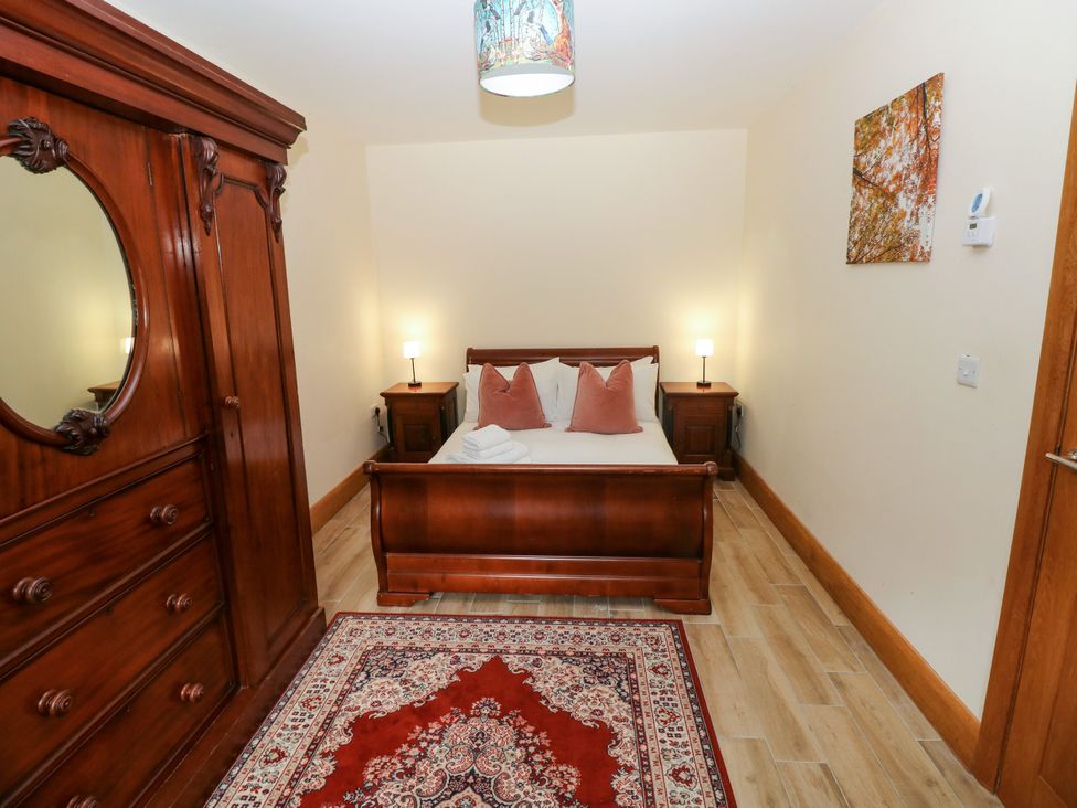 A bedroom with a bed and wardrobe at Ty-Gan Dderwen in Llangennech, Llanelli