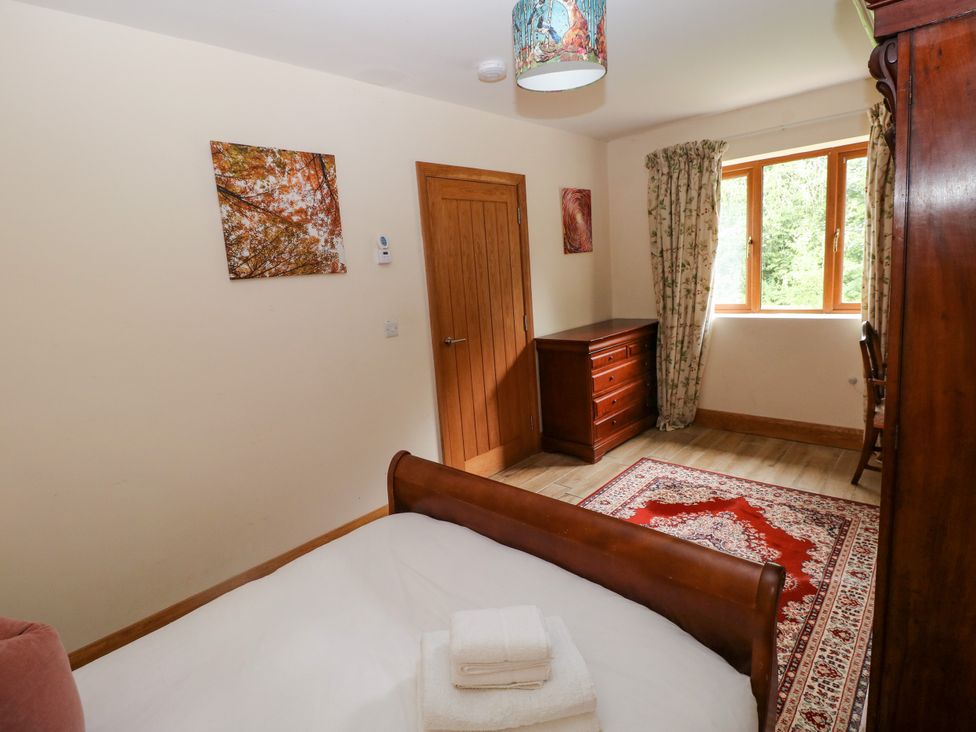A bedroom with a bed and dresser at Ty-Gan Dderwen, Llangennech, Llanelli