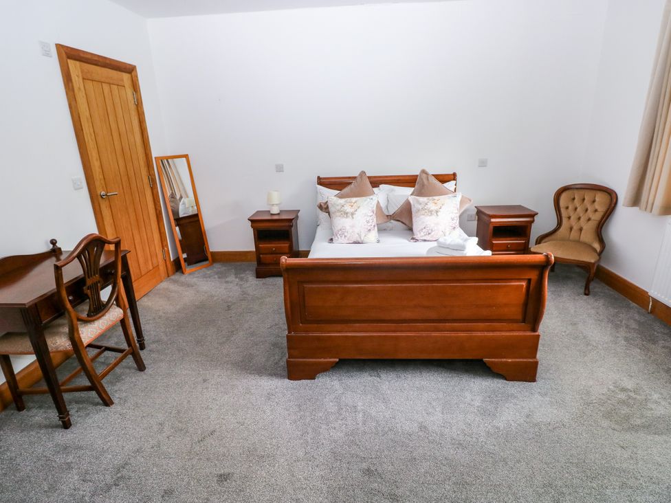 A bedroom with a bed and bedside tables at Ty-Gan Dderwen in Llangennech, Llanelli