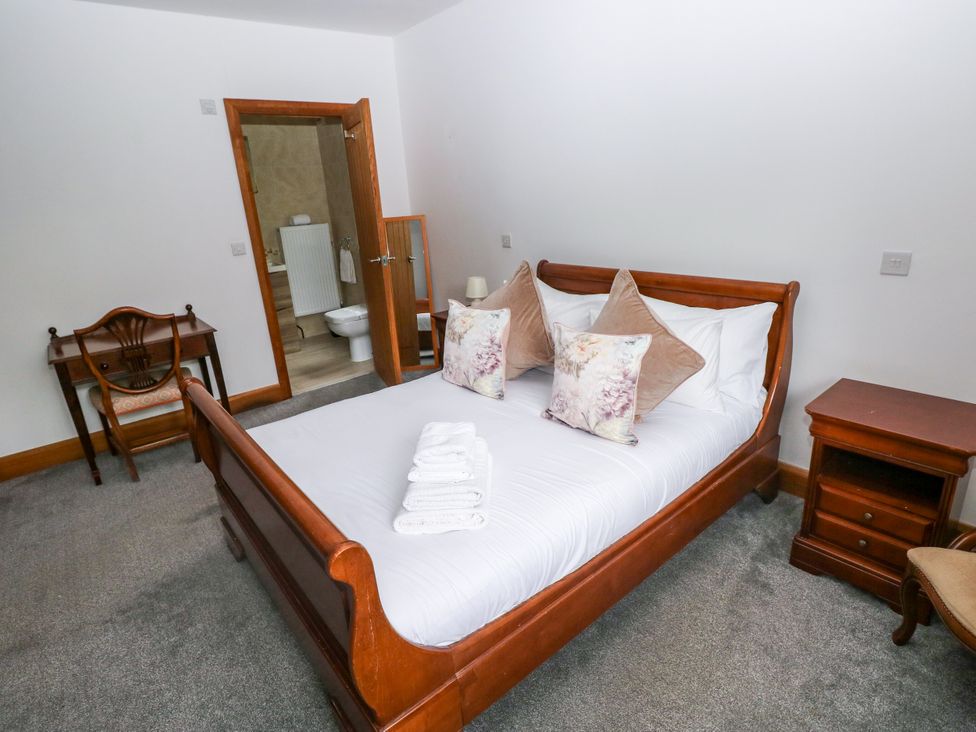 A bedroom with a bed and chair at Ty-Gan Dderwen in Llangennech, Llanelli