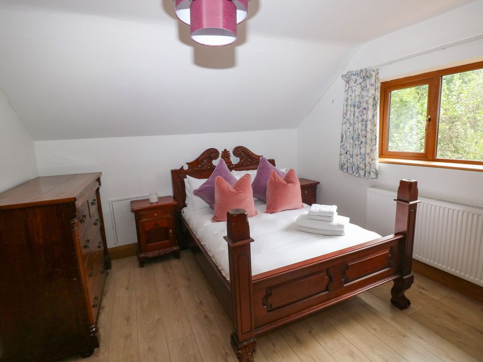 A bedroom with a bed and dresser at Ty-Gan Dderwen in Llangennech, Llanelli