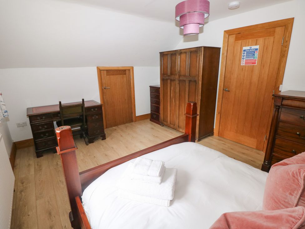 A bedroom with a bed and desk at Ty-Gan Dderwen, Llangennech, Llanelli