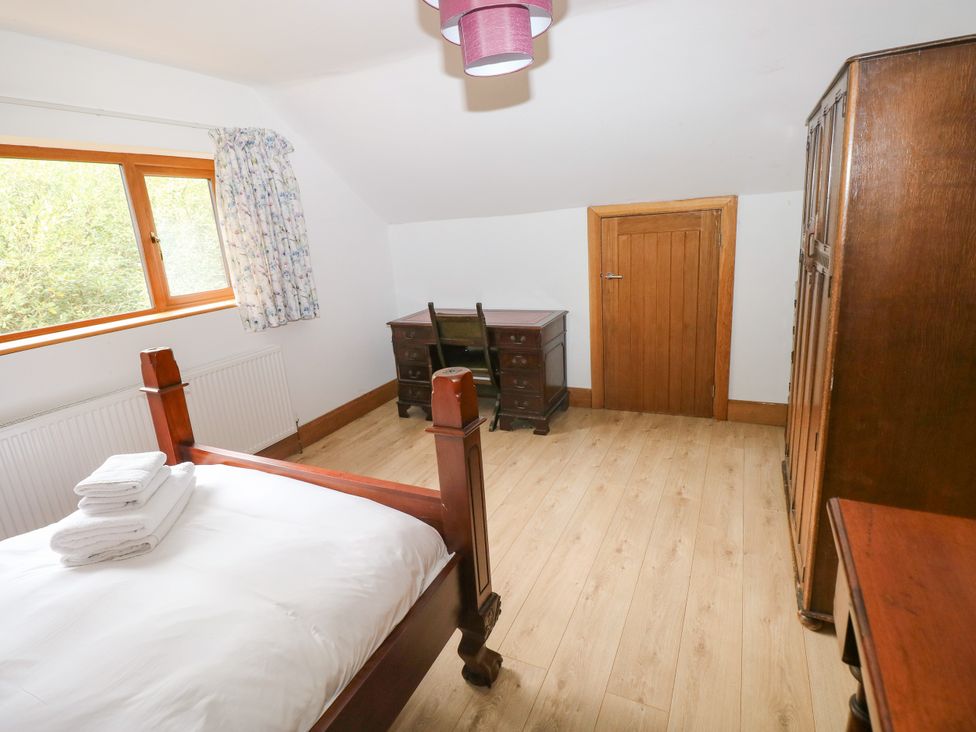 A bedroom with a bed and a desk at Ty-Gan Dderwen in Llangennech, Llanelli