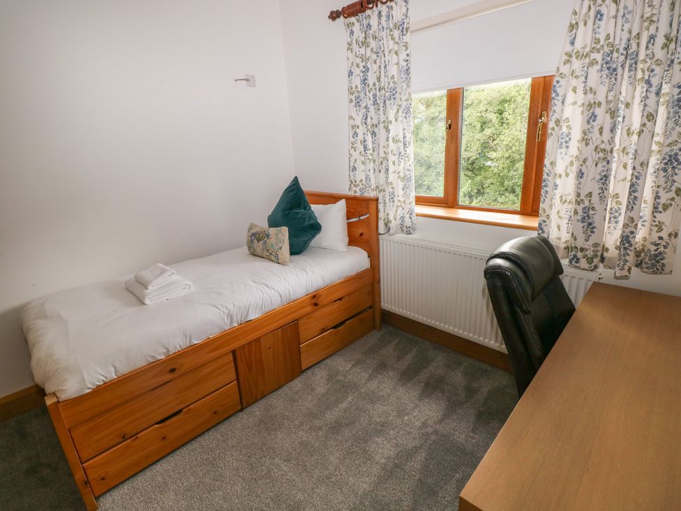 A bedroom with a bed and desk at Ty-Gan Dderwen in Llangennech, Llanelli