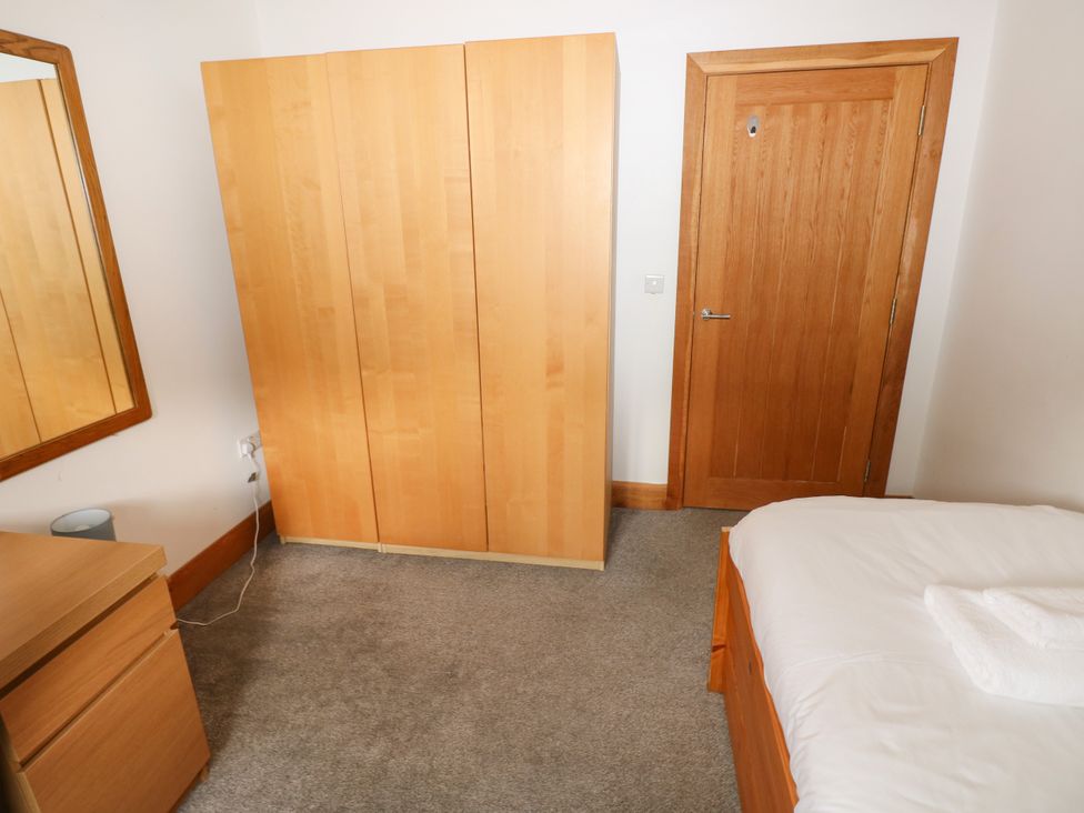 A bedroom with a wardrobe and a mirror at Ty-Gan Dderwen in Llangennech, Llanelli