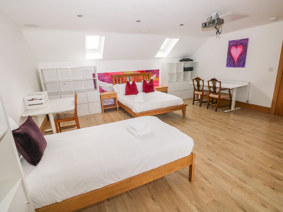 A bedroom with two beds and a desk at Ty-Gan Dderwen in Llangennech, Llanelli