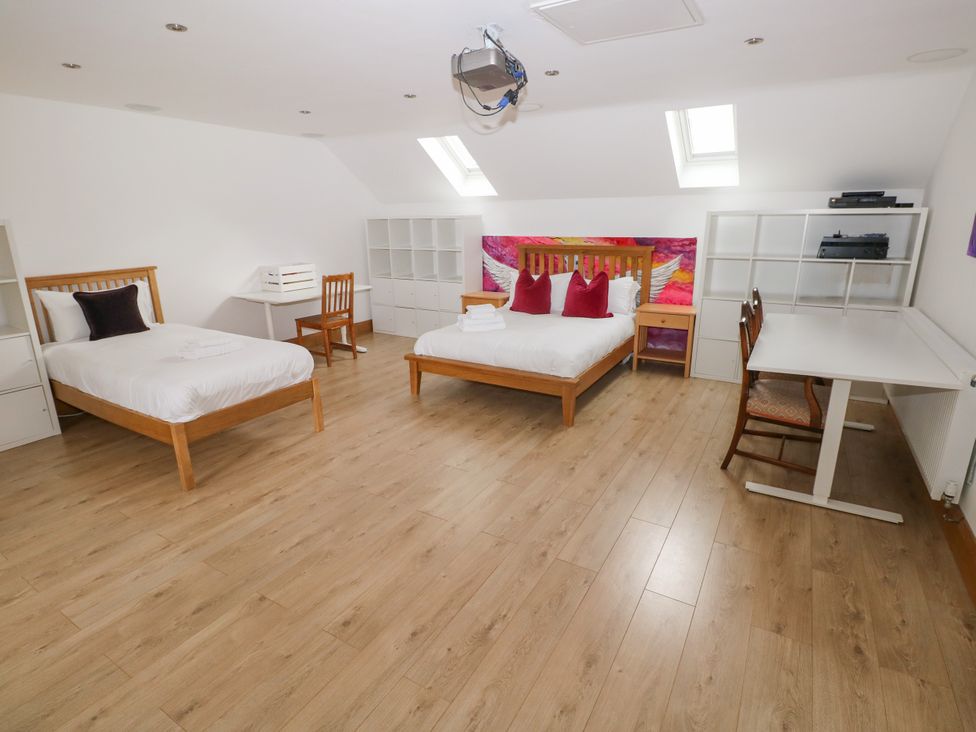 A bedroom with two beds and a study area at Ty-Gan Dderwen in Llangennech, Llanelli