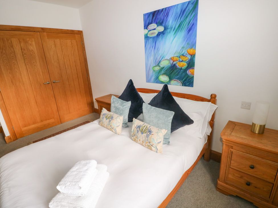 A bedroom with a bed and artwork on the wall at Ty-Gan Dderwen Llangennech, Llanelli