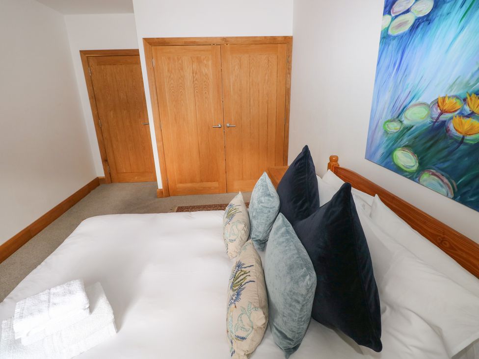 A bedroom with a bed and artwork at Ty-Gan Dderwen, Llangennech, Llanelli