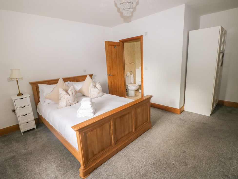 A bedroom with a bed and wardrobe at Ty-Gan Dderwen, Llangennech, Llanelli