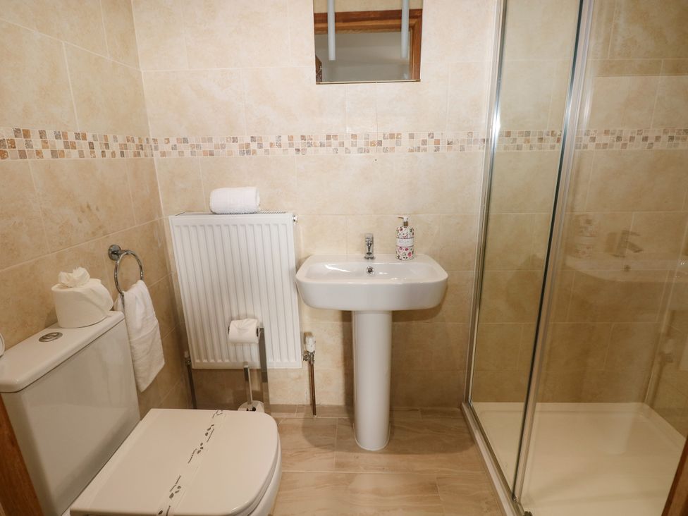 A bathroom with a sink, toilet, and shower at Ty-Gan Dderwen Llangennech, Llanelli
