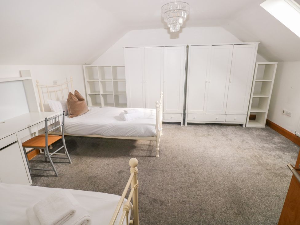 A bedroom with a bed, desk and wardrobe at Ty-Gan Dderwen Llangennech, Llanelli