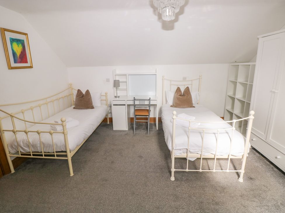 A bedroom with two beds and a desk at Ty-Gan Dderwen in Llangennech, Llanelli