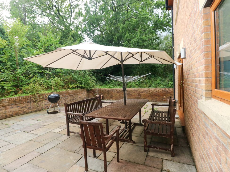 An outdoor patio with a table and chairs at Ty-Gan Dderwen in Llangennech, Llanelli