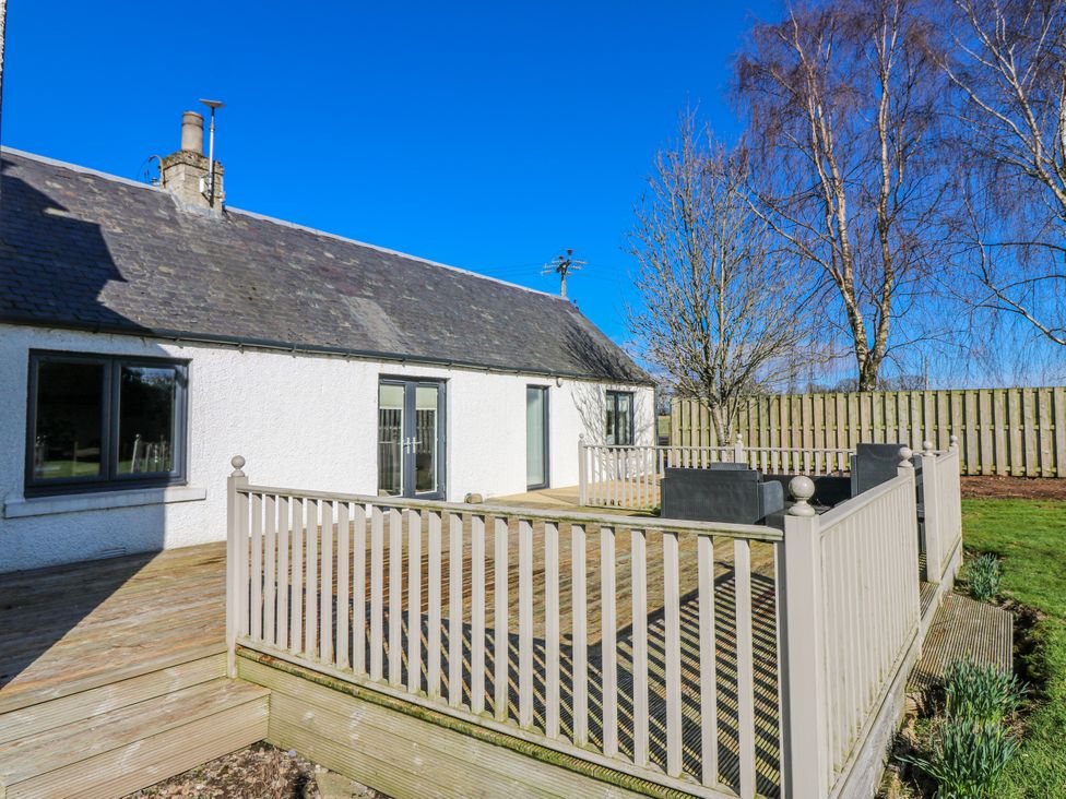 An outdoor area with decking, a table and chairs at Norwood