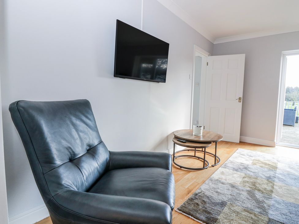 A living room with a leather chair and a television at Norwood