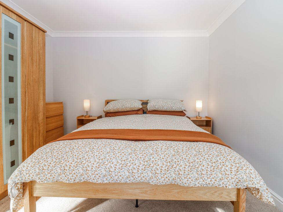 A bed with side lamps and a dresser at Norwood